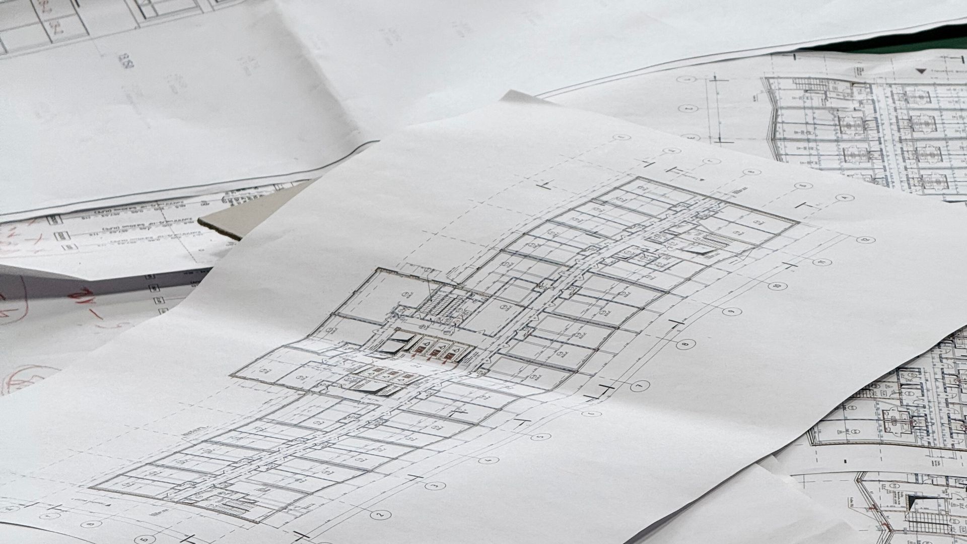 Close-up of architectural blueprint sheets spread across a drafting table