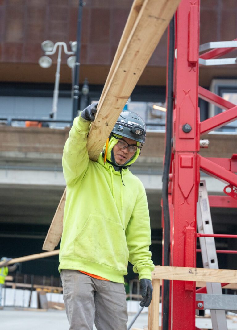 Carpenter carrying timber during framing work