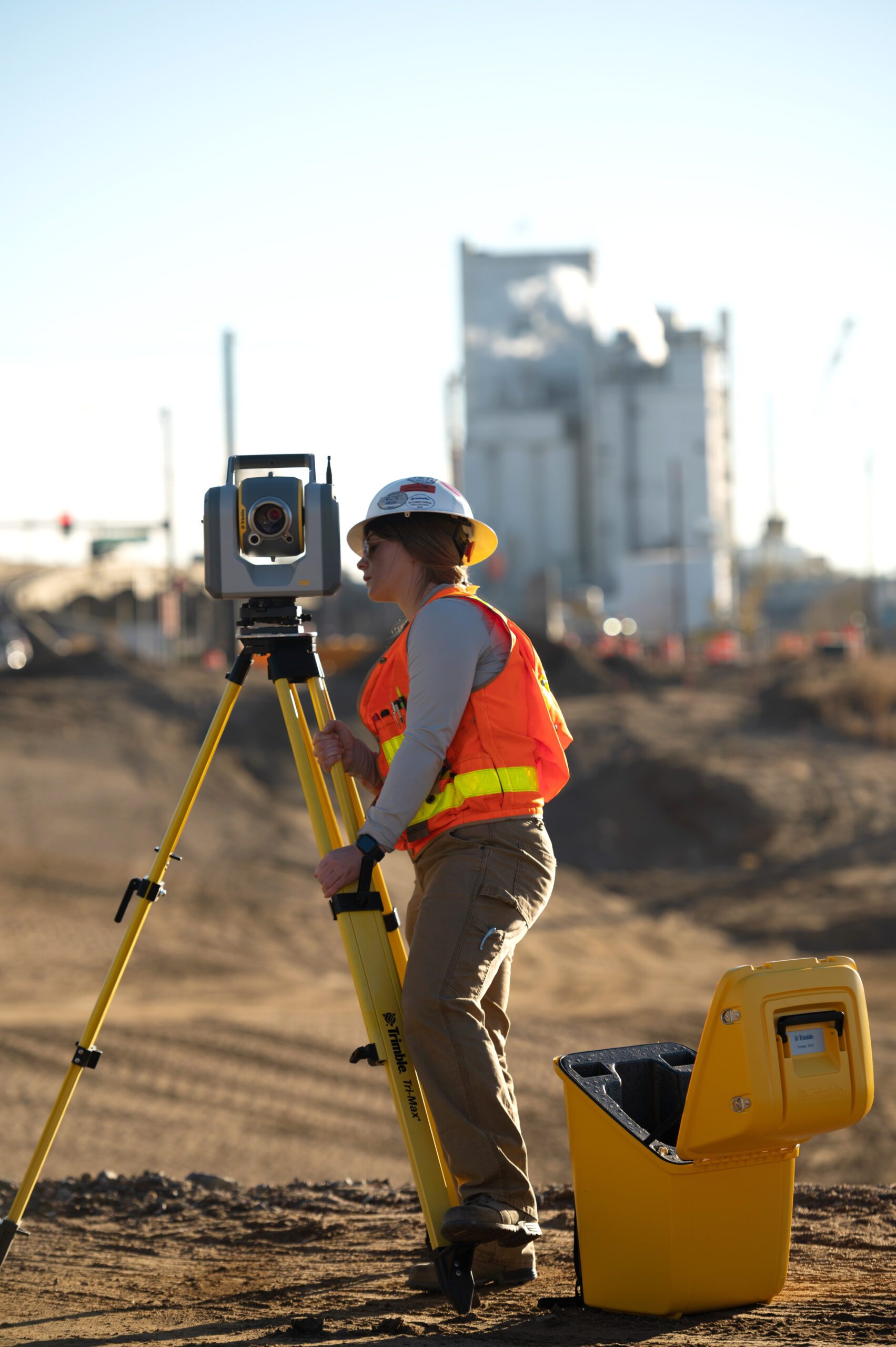 Surveyor operating a total station at an earthworks site